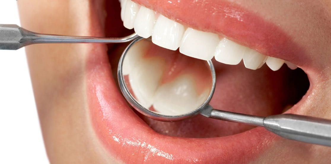دندانپزشک در حال انجام ترمیم دندان و زیبایی دندان با روشهای دندانپزشکی ترمیمی است